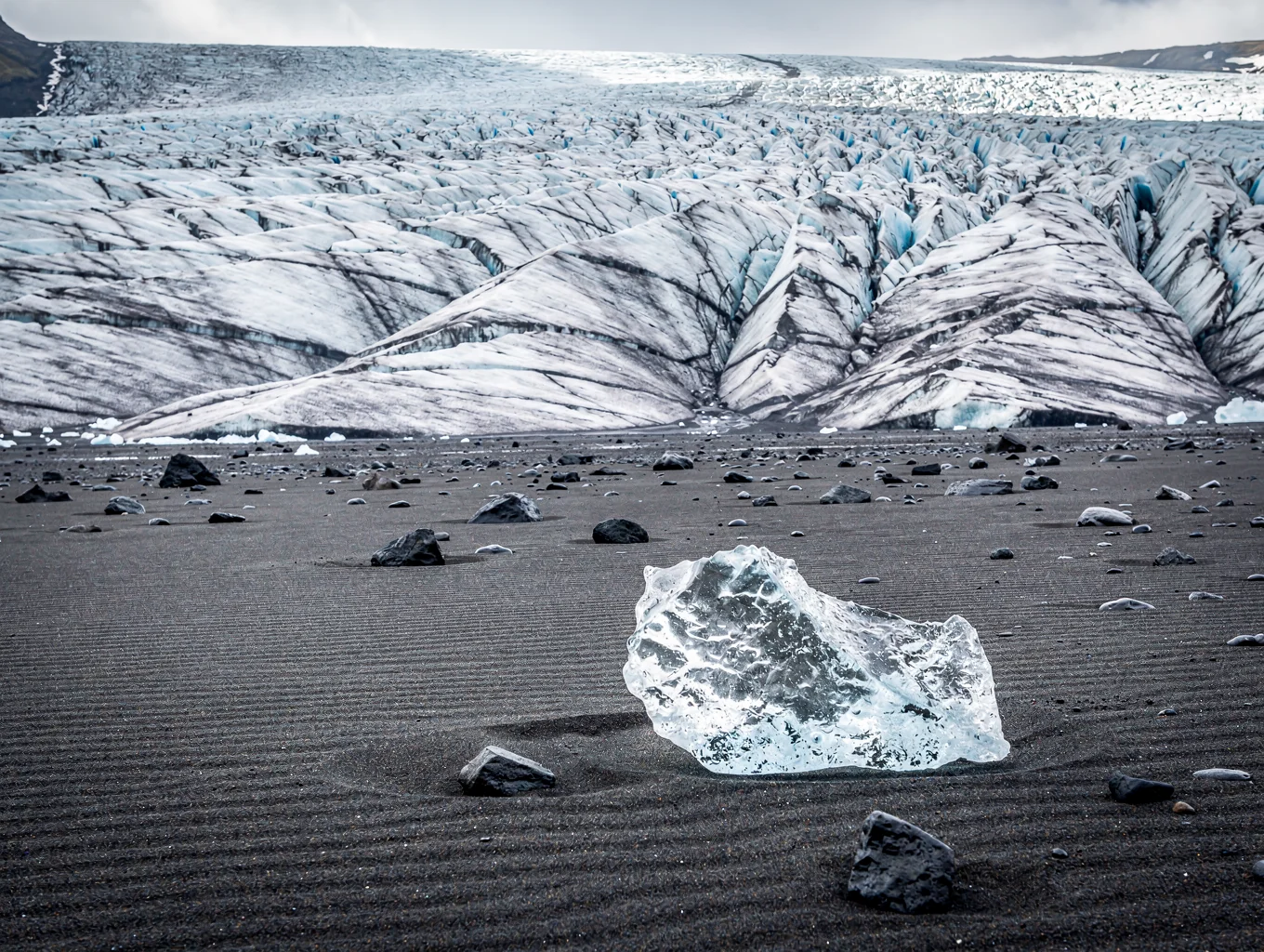 Blue glacial ice fragments resting on black volcanic sand