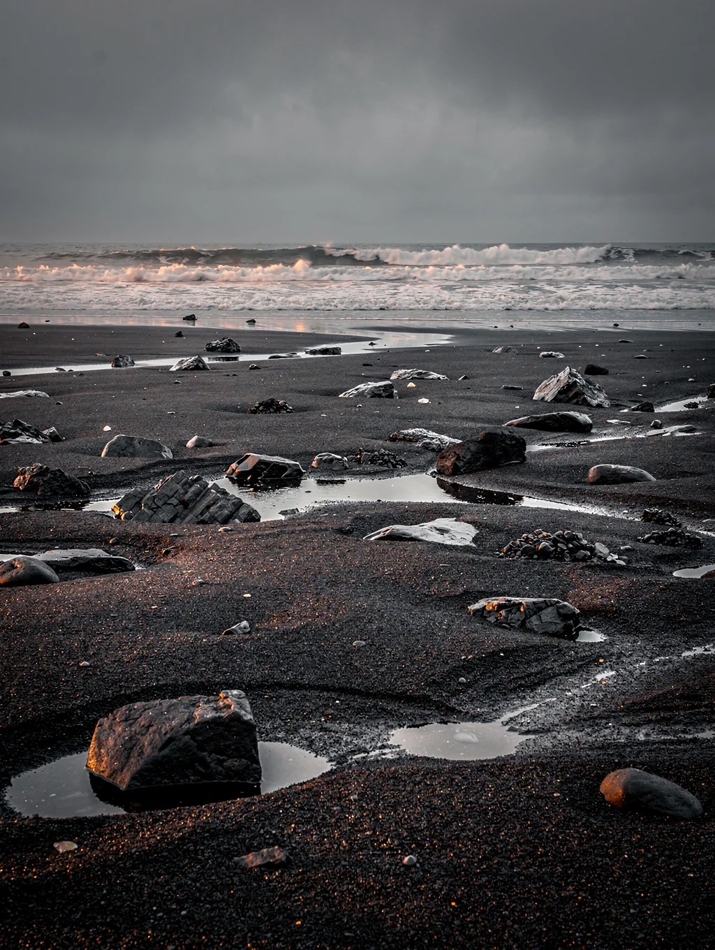 Black volcanic sand and blue glacial ice on Icelandic shore
